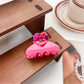 Beau medium heart shaped half circle claw clip resting on a wooden surface