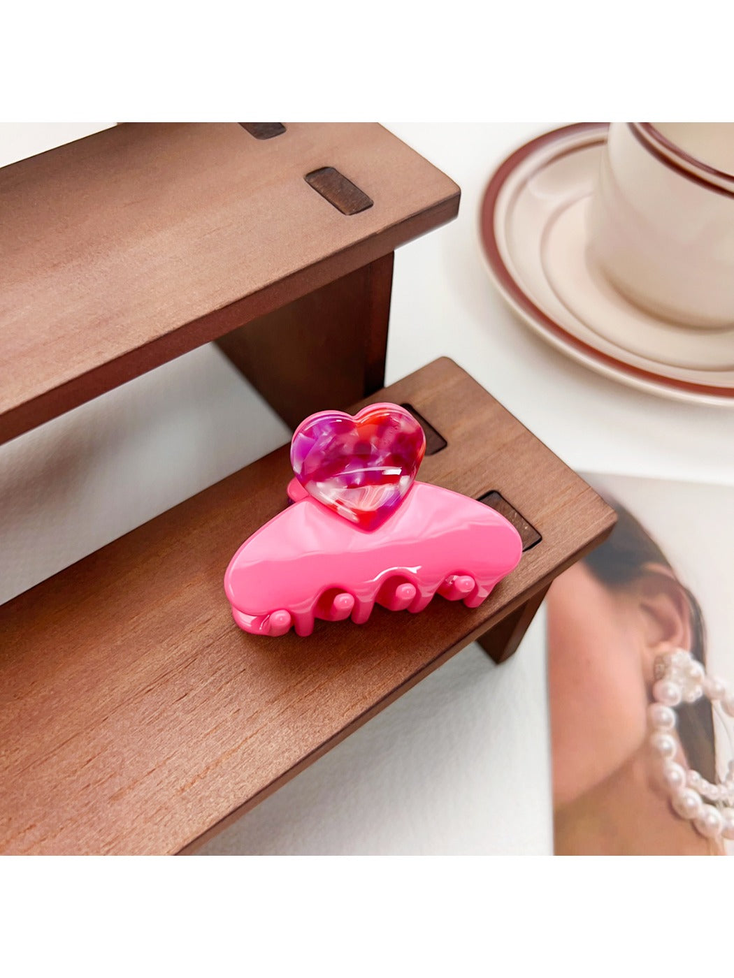 Beau medium heart shaped half circle claw clip resting on a wooden surface
