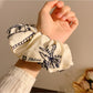 Side view of elastic scrunchie featuring vintage coconut tree pattern
