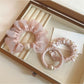 Close-up of the pink mini scrunchie showing its gathered fabric texture