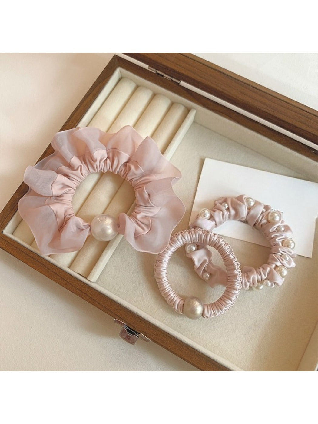 Close-up of the pink mini scrunchie showing its gathered fabric texture