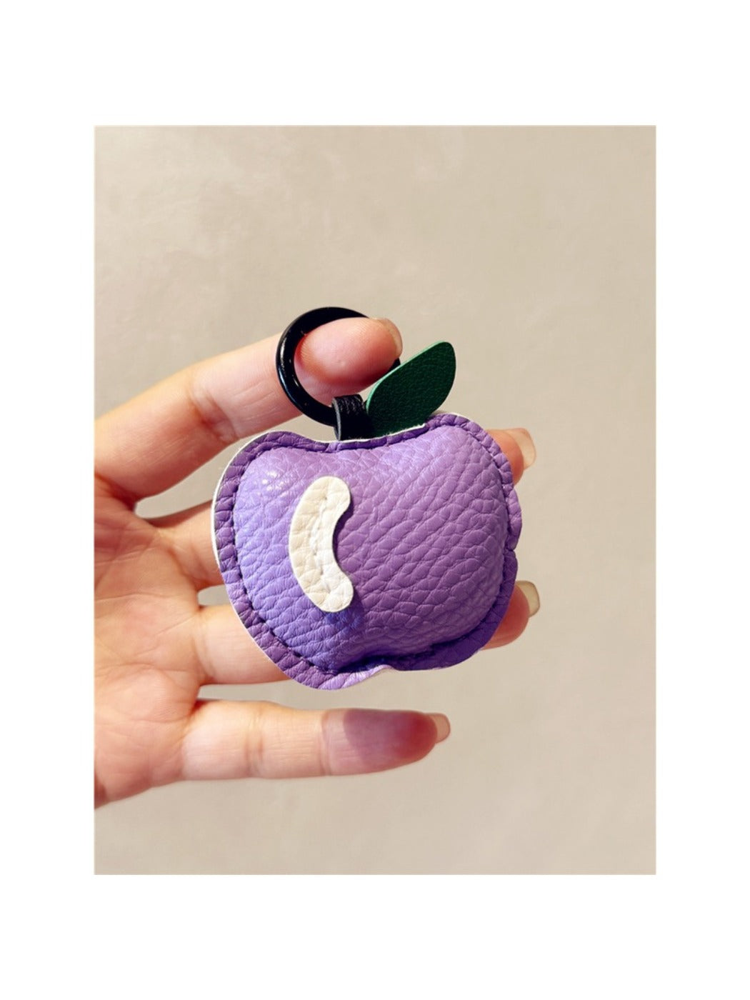 Apple shaped keychain displayed next to a ruler for size reference
