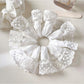 White lace trim scrunchie styled on a model's wrist