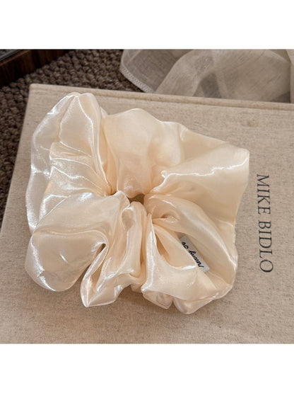 Beige satin scrunchie styled on a wrist as a bracelet accessory