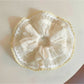 Close-up of Gifty minimalist modern ruched scrunchie in soft beige fabric