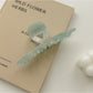 Beau claw clip placed on wooden surface emphasizing gradient colors