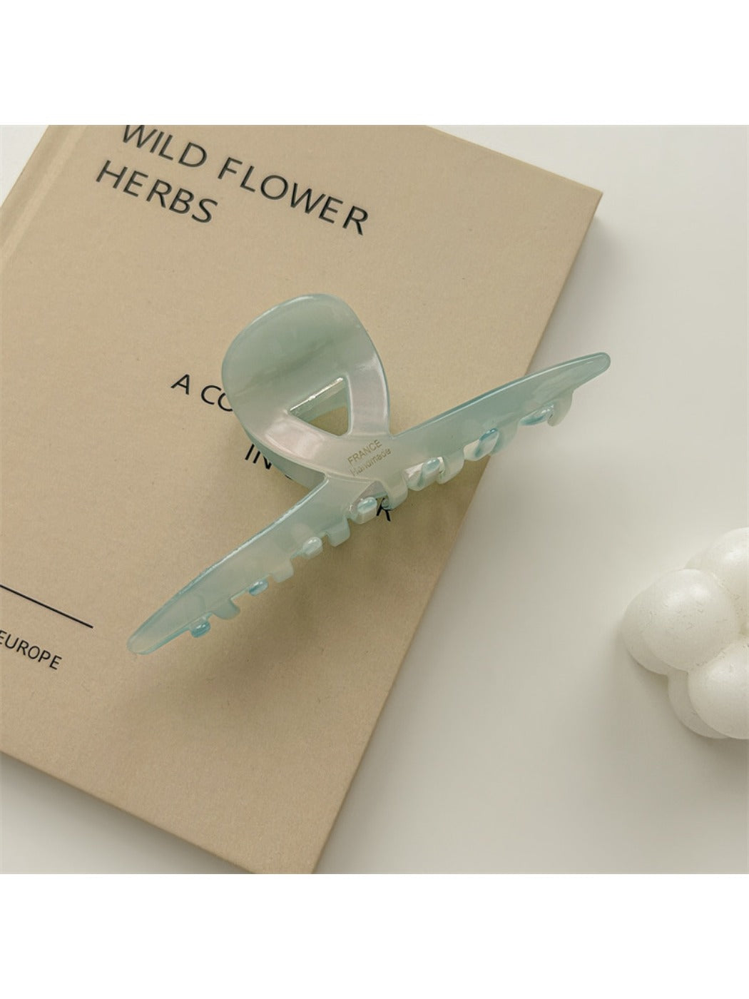 Beau claw clip placed on wooden surface emphasizing gradient colors