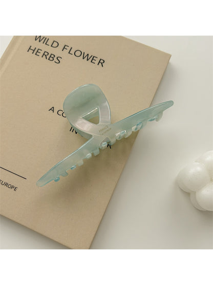 Beau claw clip placed on wooden surface emphasizing gradient colors