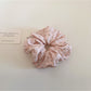 Gifty floral scrunchie displayed alongside matching floral accessories on a wooden surface
