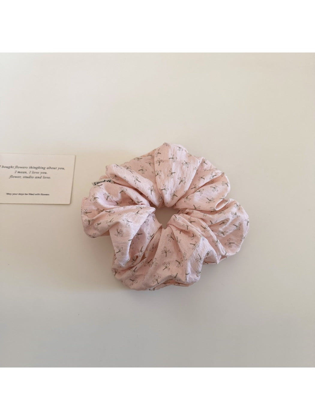 Gifty floral scrunchie displayed alongside matching floral accessories on a wooden surface