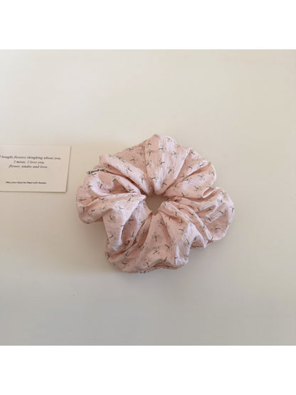 Gifty floral scrunchie displayed alongside matching floral accessories on a wooden surface