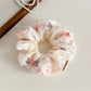 Gifty ombre print scrunchie displayed flat highlighting its elastic and gathered fabric design