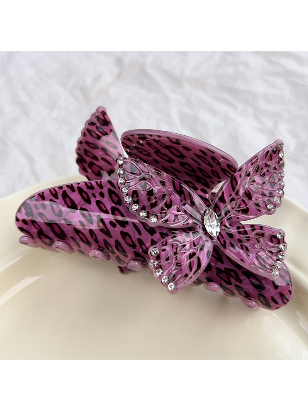 Beau leopard print claw clip with butterfly detail against neutral background