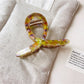 Beau vintage crisscross hair claw clip displayed on a white background