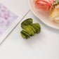 Beau fresh acetate hair clip placed on wooden surface with soft shadows
