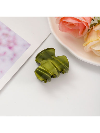 Beau fresh acetate hair clip placed on wooden surface with soft shadows