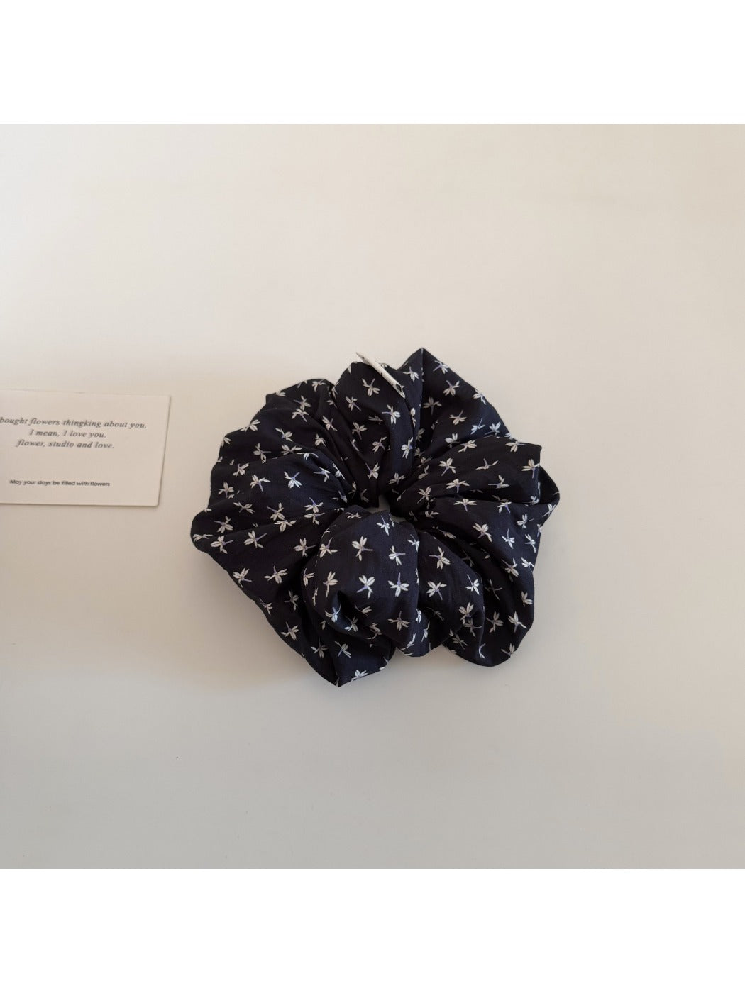 Model wearing Gifty elegant ditsy floral scrunchie in a casual updo hairstyle outdoors