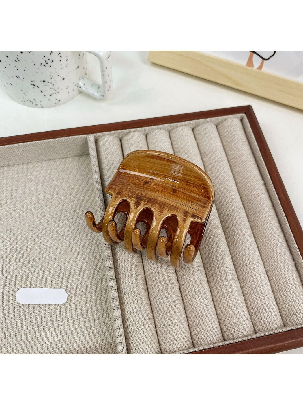 Beau hair claw clip placed on wooden surface with natural lighting