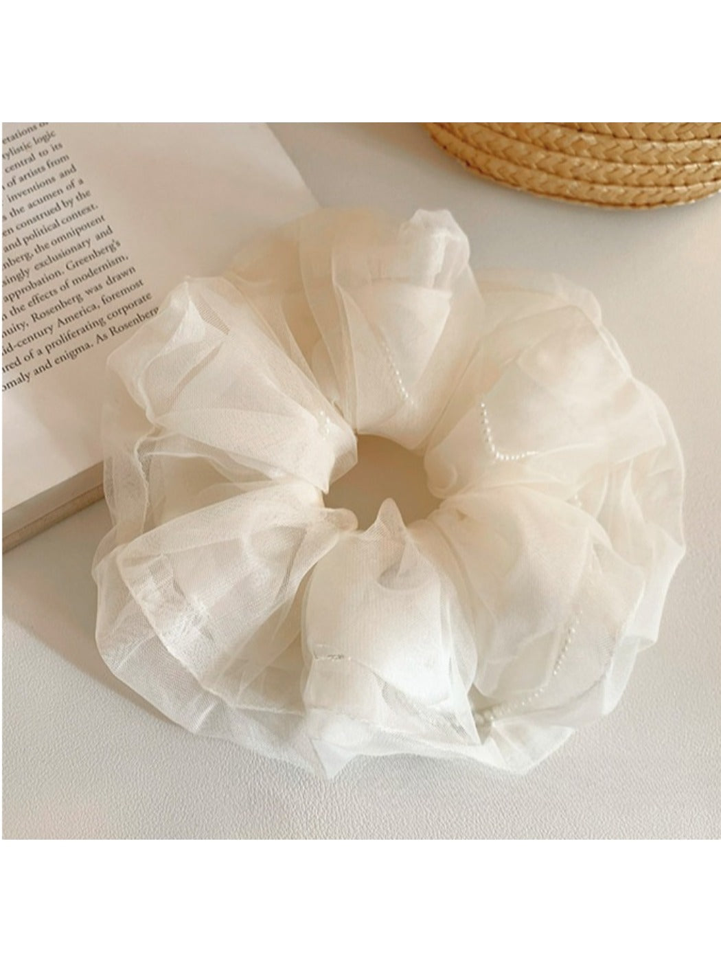 Soft beige tulle scrunchie with gathered fabric detail on a white background