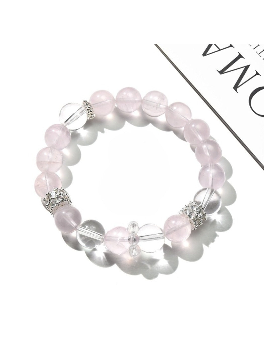 Lovra bracelet featuring alternating pink and white crystal beads displayed flat