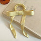 Side view of Gifty satin yellow ribbon bow scrunchie highlighting fabric texture