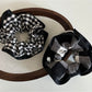 Black and white checkered scrunchie with black edge on a white background