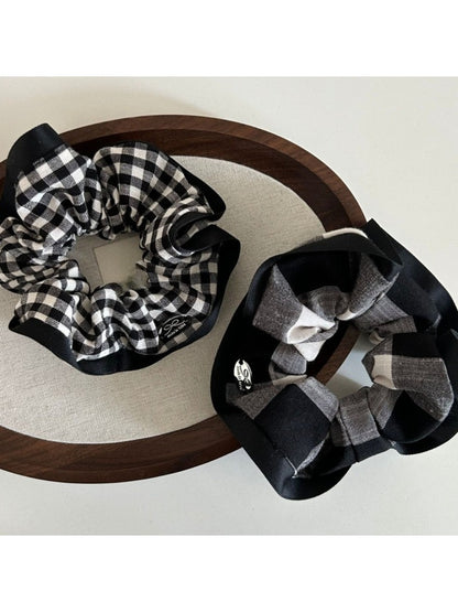 Black and white checkered scrunchie with black edge on a white background