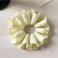 Delicate yellow checkered scrunchie with soft fabric texture
