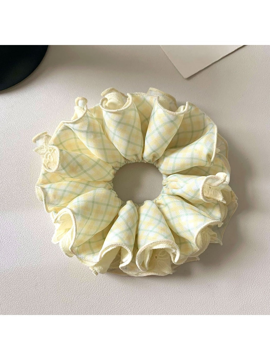 Delicate yellow checkered scrunchie with soft fabric texture
