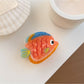 Beau fish claw clip showing the spring clasp and colorful fish design