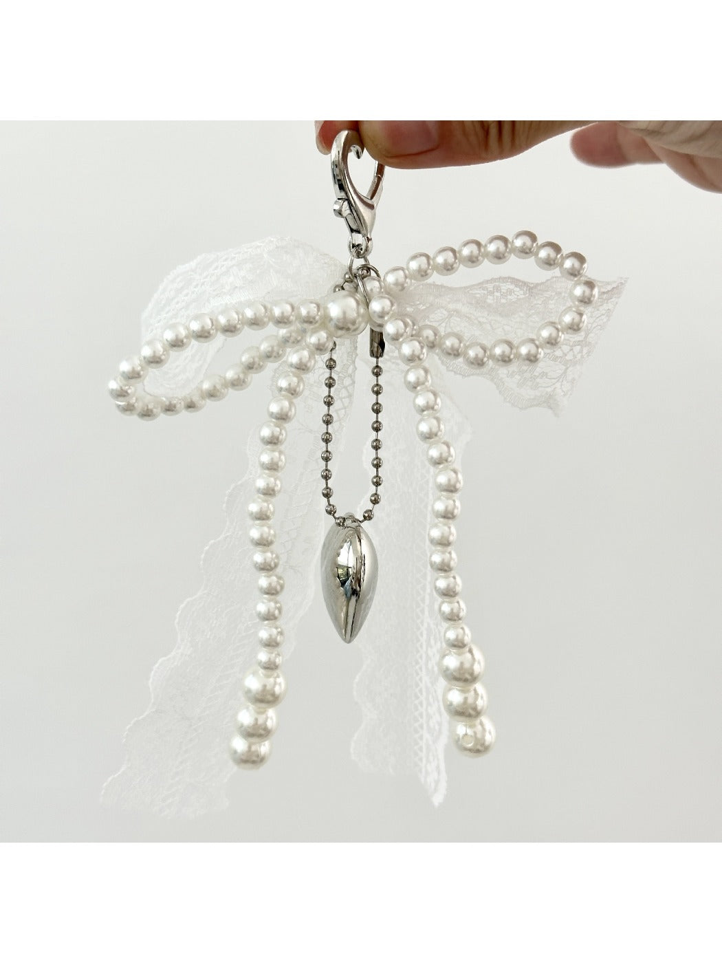 Top view of the lace bow keychain showing intricate lace details and gold ring