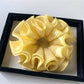 Gifty scrunchie placed next to matching minimalist outfit accessories