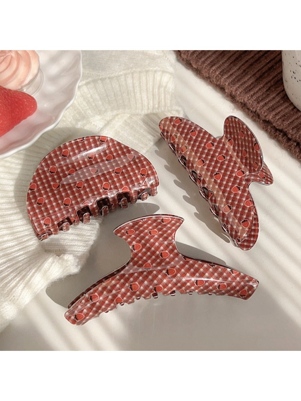 Side view of Beau plaid strawberry print hair claw clip with metal clasp