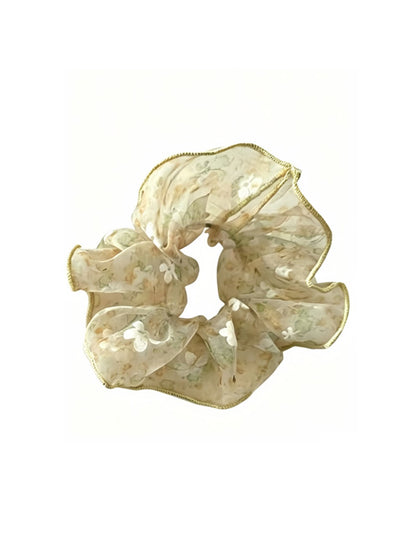 Gifty sheer tulle scrunchie worn on a wrist, highlighting its lightweight and floral details