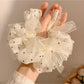 Close-up of white polka dot tulle scrunchie showing fabric texture