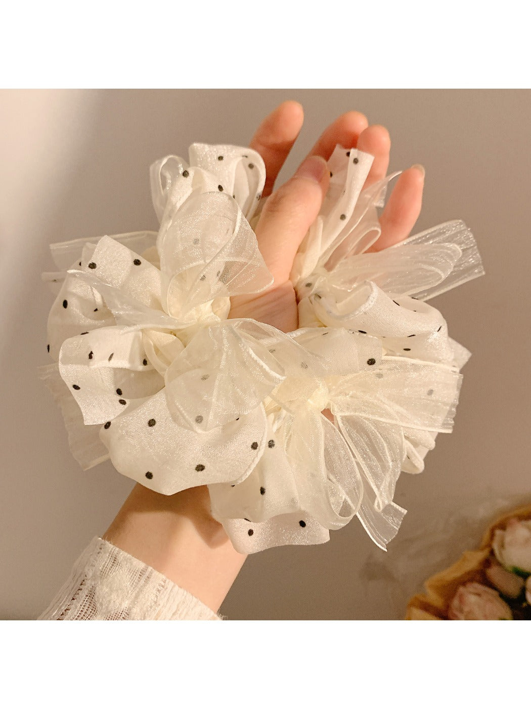 Close-up of white polka dot tulle scrunchie showing fabric texture