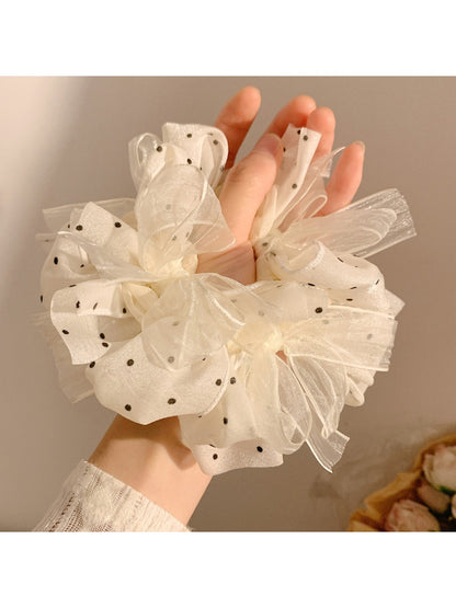 Close-up of white polka dot tulle scrunchie showing fabric texture