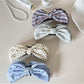 Beau elegant bow banana clip in glossy black, side view on white background
