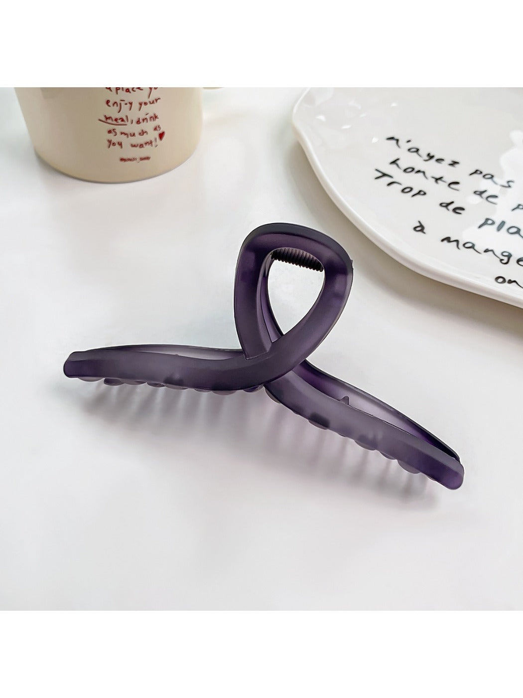 Beau square crisscross hair claw clip displayed on a wooden surface