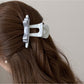Beau T shaped bow hair claw clip holding brown hair in a half-up style