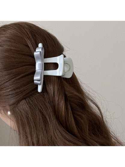 Beau T shaped bow hair claw clip holding brown hair in a half-up style