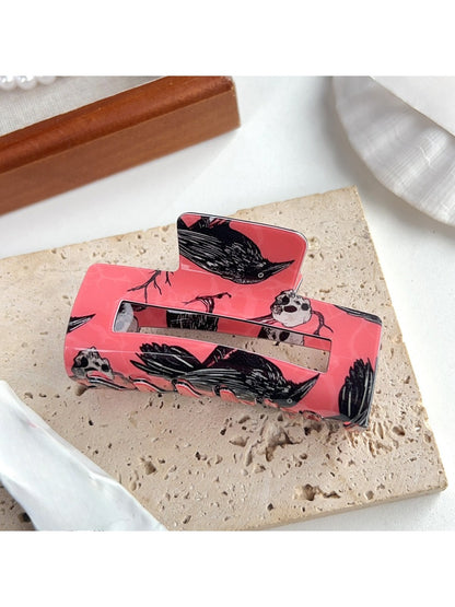 Beau crow pattern hair claw clip on white background, angled view