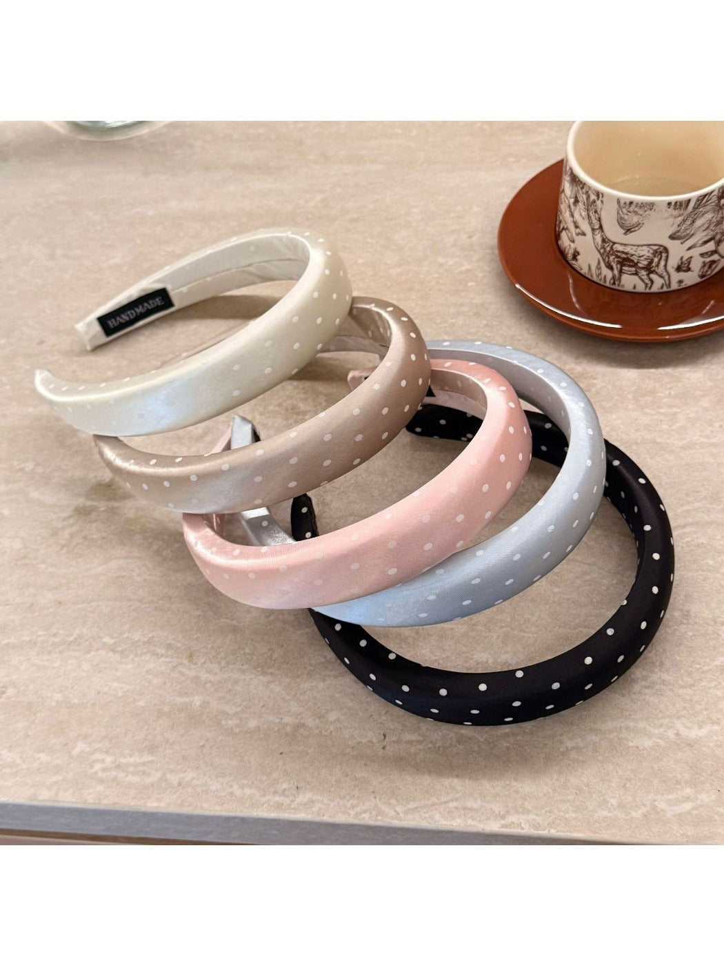 Side view of the pink polka dot headband showing its width and texture