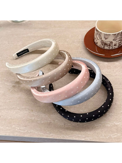 Side view of the pink polka dot headband showing its width and texture