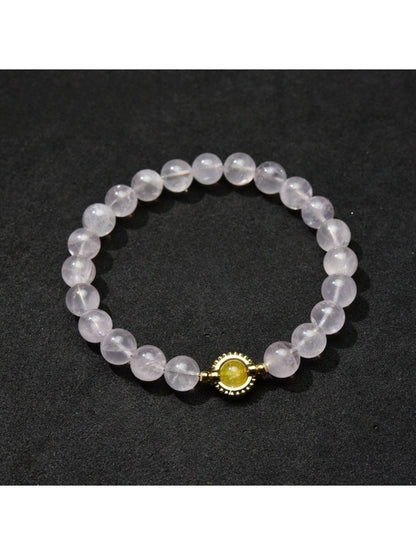 Lovra minimalist bracelet next to a small plant, emphasizing natural and simple style