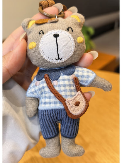 Bear charm keychain attached to a handbag zipper pull