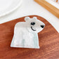 Beau hair claw clip in beige color displayed on wooden surface