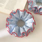 Gifty ruffle scrunchie styled on a wrist with a casual outfit
