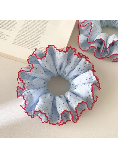 Gifty ruffle scrunchie styled on a wrist with a casual outfit