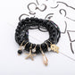 Multiple Lovra stackable bracelets layered on wrist featuring ocean-themed pendants